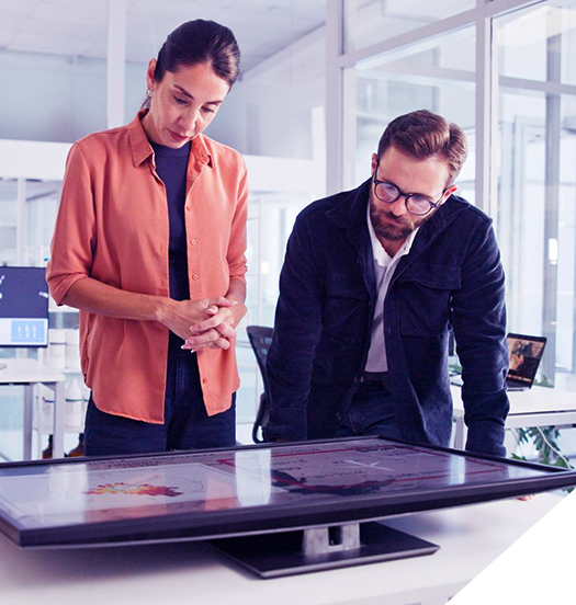 Profesionales analizando datos y gráficos en una gran pantalla digital en una oficina de diseño contemporáneo.