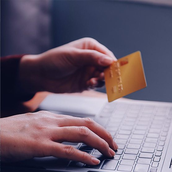 Usuario realizando transacciones bancarias en línea con tarjeta de crédito y laptop bajo protocolos de validación de identidad