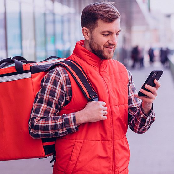 Repartidor de plataforma de entrega utilizando su smartphone para verificación de identidad y autenticación en la aplicación